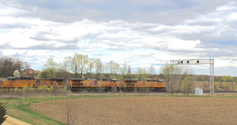 Three locomotives under cloudy skies