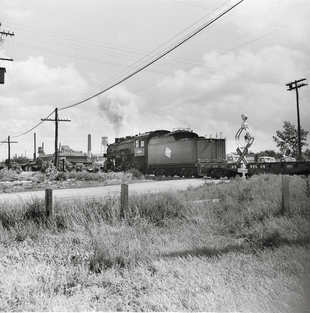 A freight locomotive passing by a field