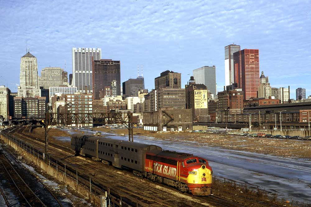 Red and yellow commuter train under Chicago skyline