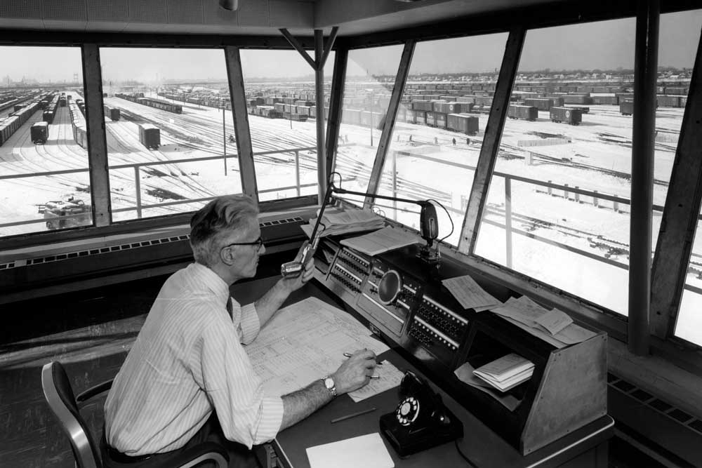 Man looks out window of yard control tower