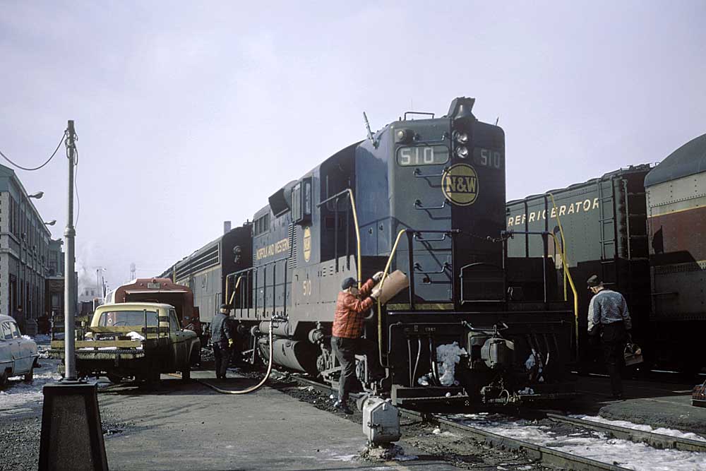 Crews service passenger train during station stop