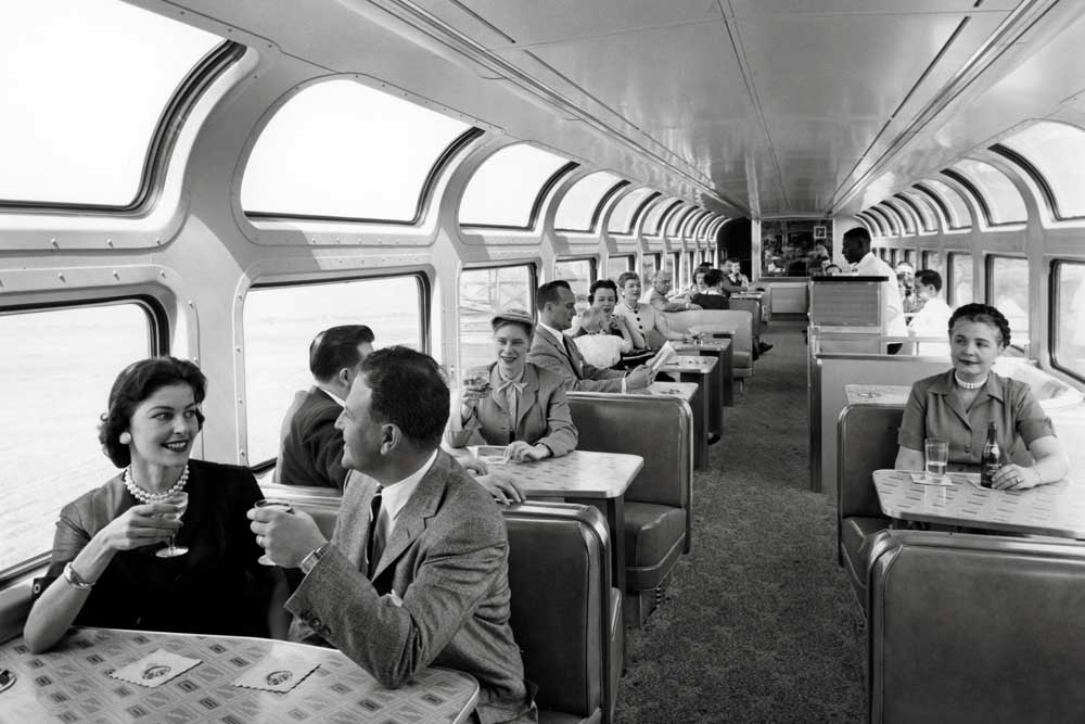 Passengers enjoy drinks in a railroad lounge car
