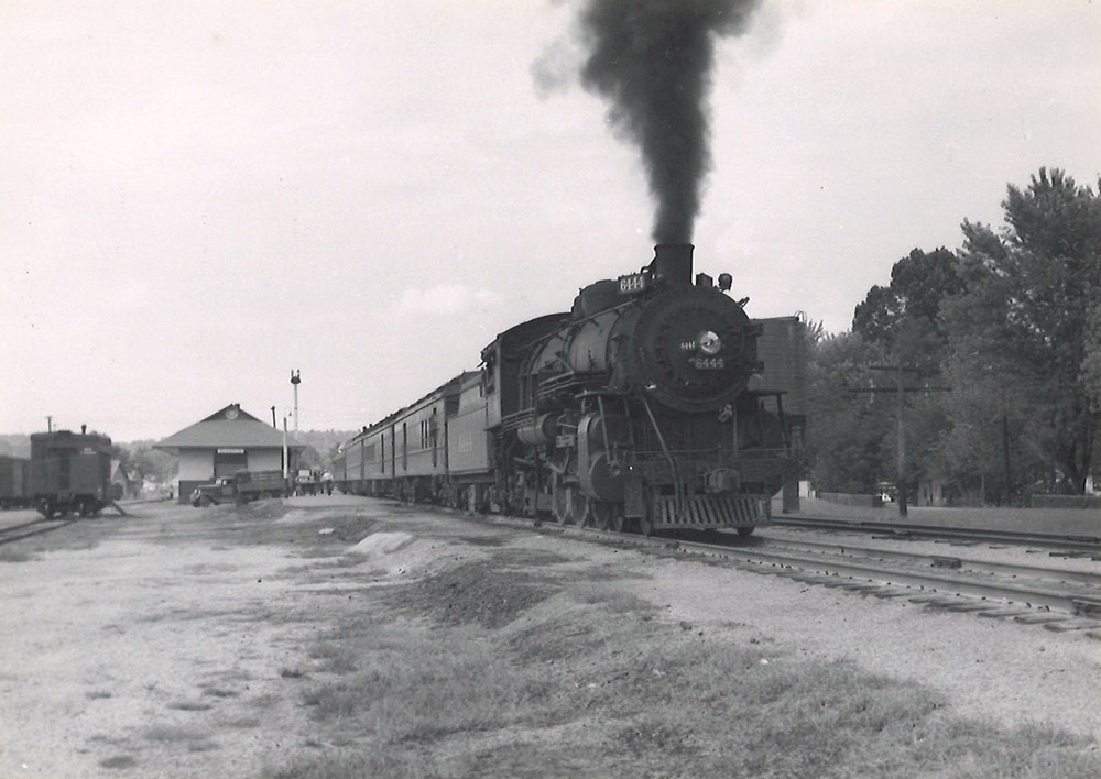 Steam locomotive with passenger train departing station
