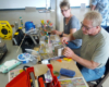 People sitting at a table building scale flatcars