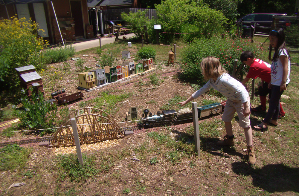 Three children watch a large-scale train display