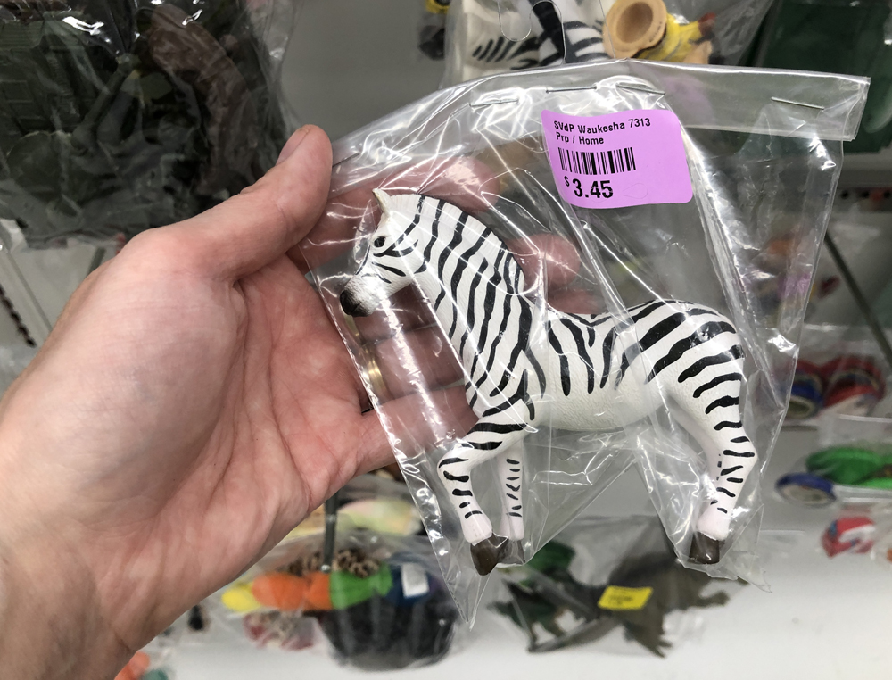 Hand holding a toy zebra