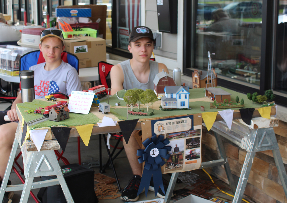 Ian and Bo sit posed behind their model layout.