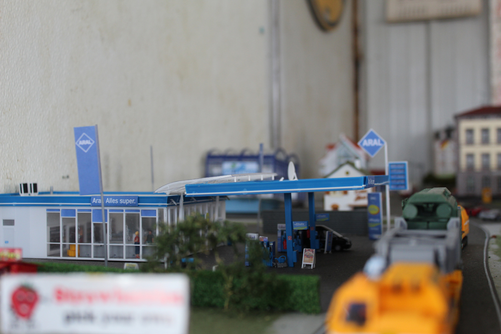 Gas station with vehicles pulled alongside it.