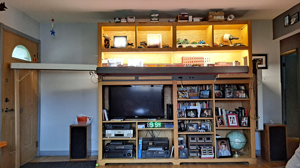 Entertainment center with lighted shelf layout in top half, staging cassette attached to left side