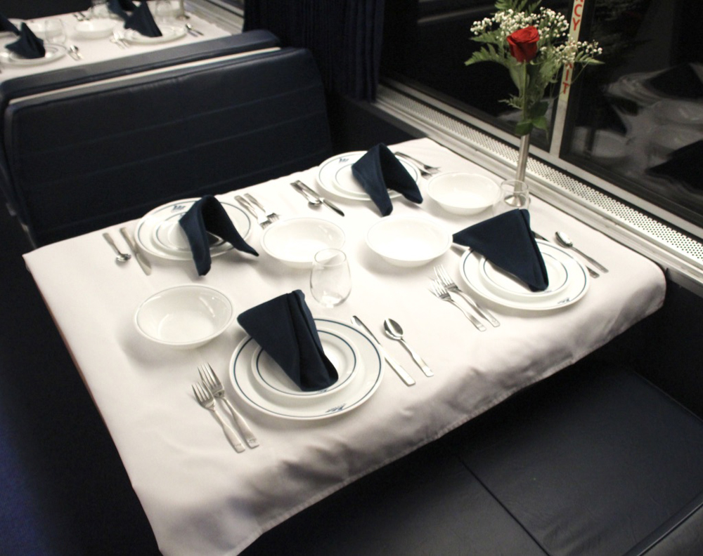 Table with Amtrak place settings, linen tablecloth and napkins