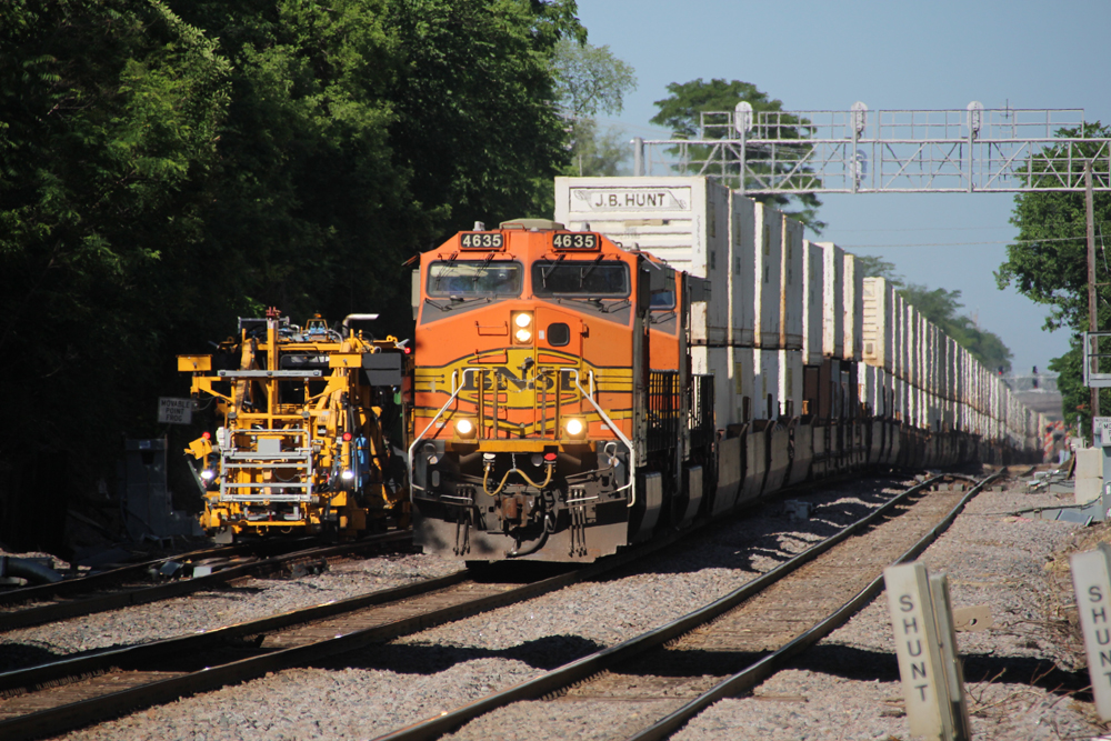 Double-stack container train passing maintenance equipment