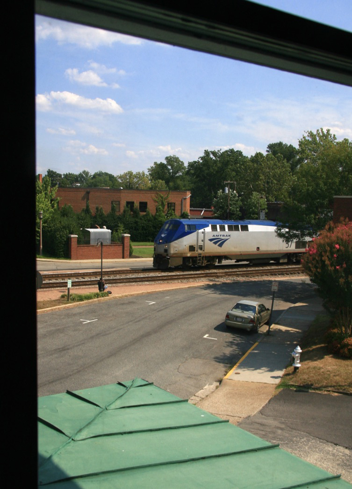 Pasenger locomotive visible across street from hotel window