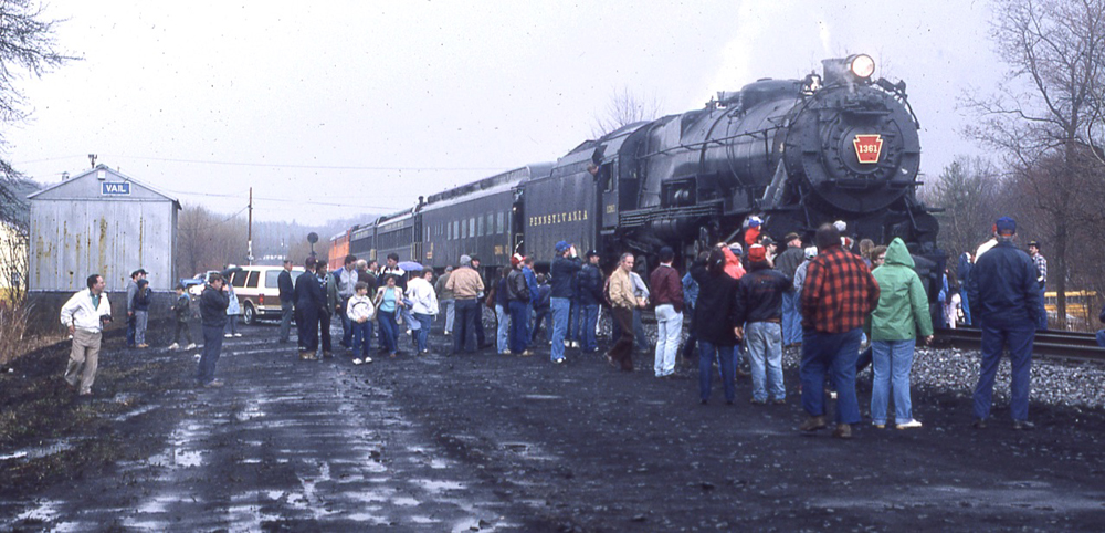 Steam locomotive with short train, surrounded by people