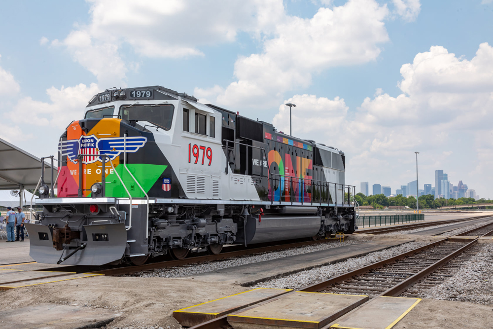 Multicolored locomotive with Houston skyline in distance