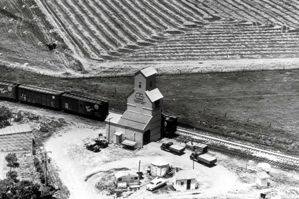 Aerial view of boxcars loading at wooden grain elevator