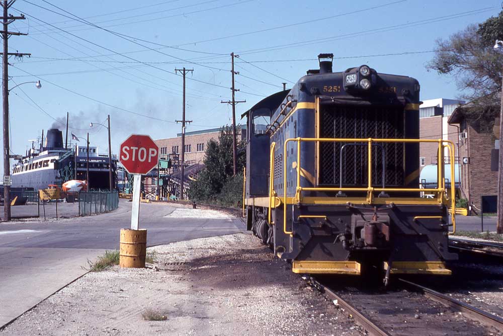 Blue diesel switcher locomotive by Great Lakes carferry boat