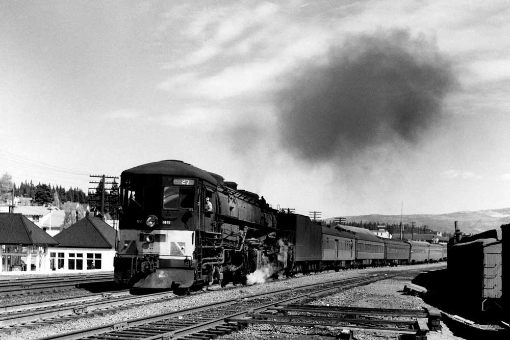 Cab-forward steam locomotive with passenger train on curve
