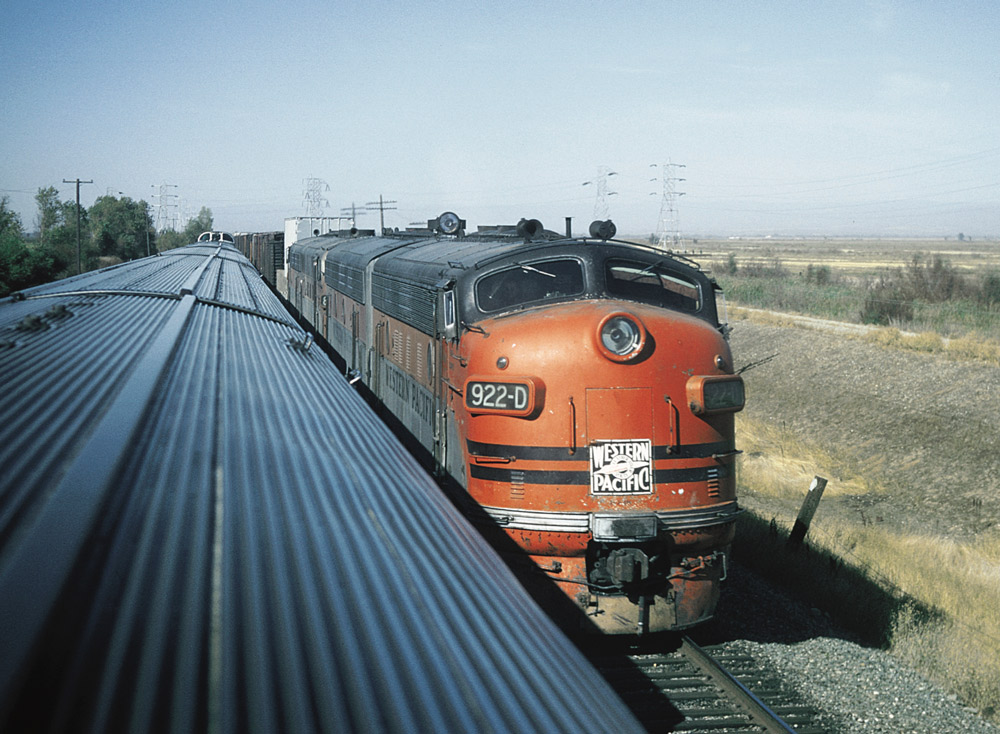 Streamlined diesel locomotive on freight train as seen from dome car of passing passenger train