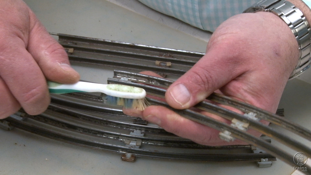 Hand cleaning tubular track with old toothbrush