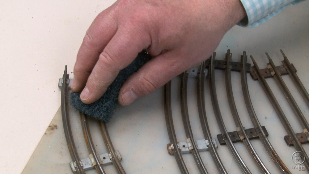 Hand cleaning tubular track with scrub brush