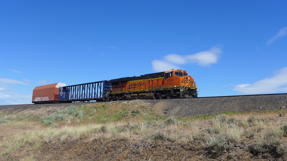 BNSF 6800, a General Electric ES44C4, hurrying westbound near Harrington, Wash. with an empty centerbeam flatcar