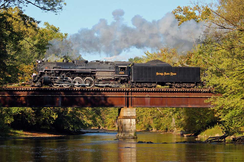 Steam locomotive crosses waterway on bridge