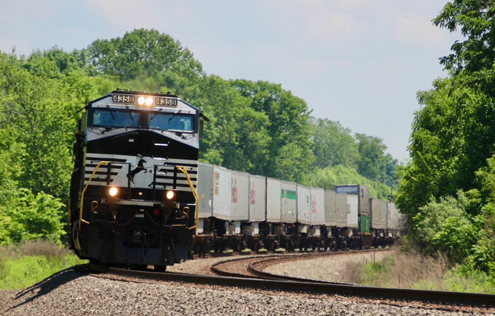 Black locomotive with train of trailers in the Midwest