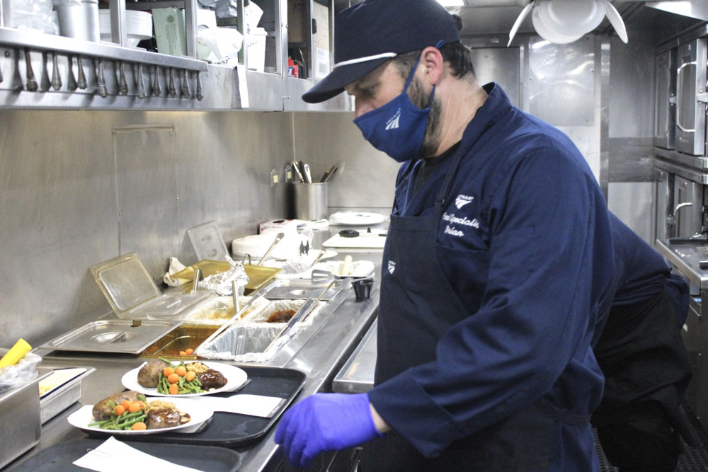 Man in blue clothing prepares to deliver food