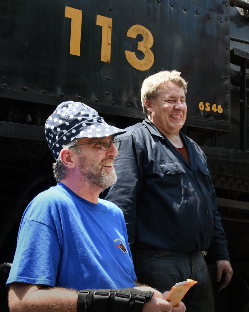 Two men in front of steam locomotive