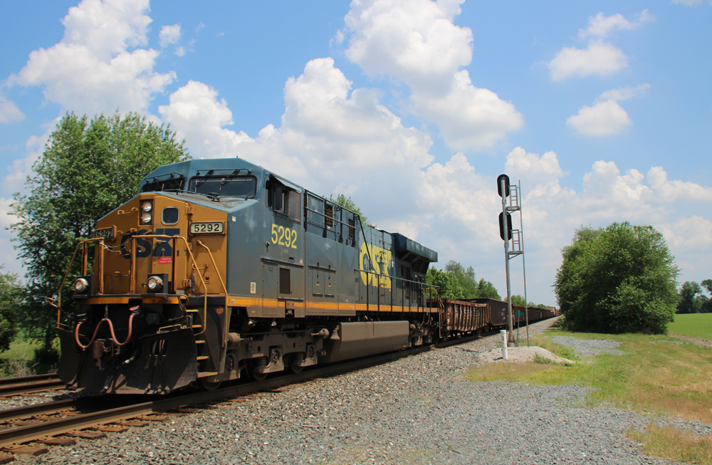 Train with one engine under blue sky with white clouds