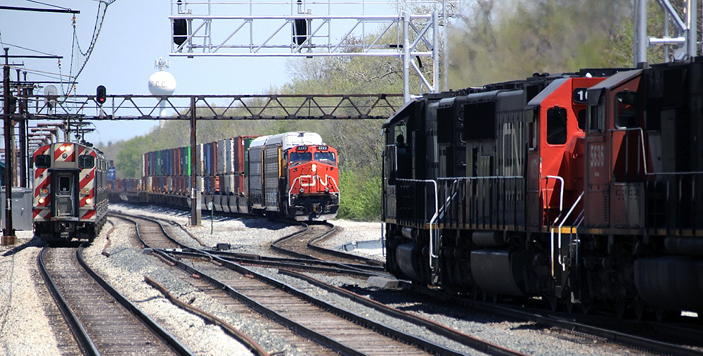 Electrified commuter train meets two freight trains
