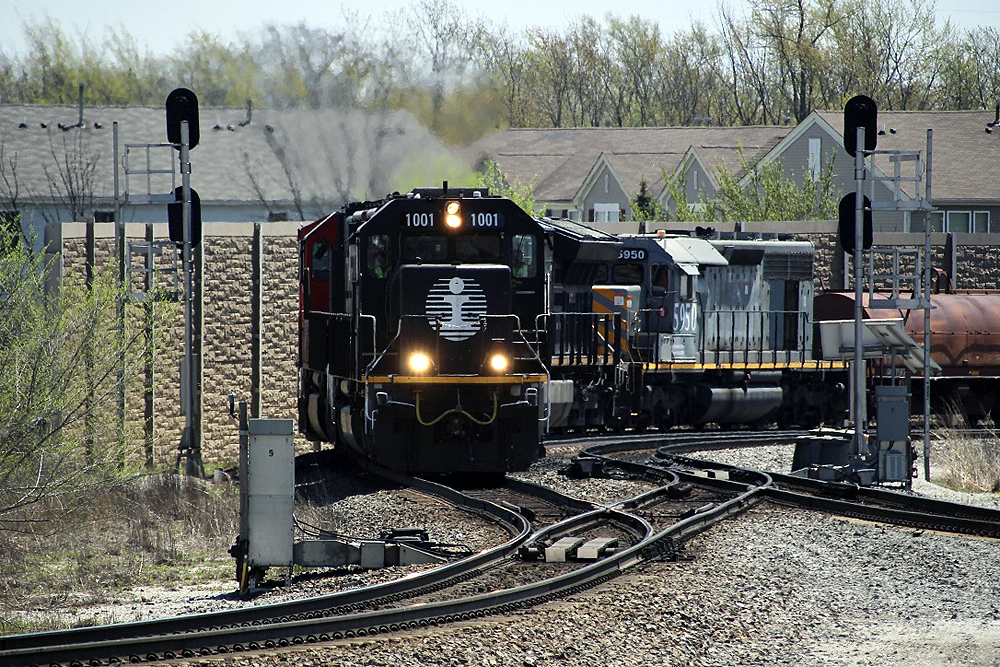 Black locomotive leads train through sharp curve