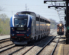 Blue and silver locomotive leads train of bilevel passenger cars