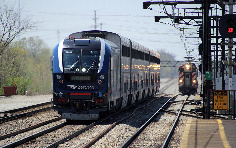 Passenger train with bilevel equipment passes electrified commuter train