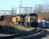 Two yellow diesels bring train downhill on sharp curve