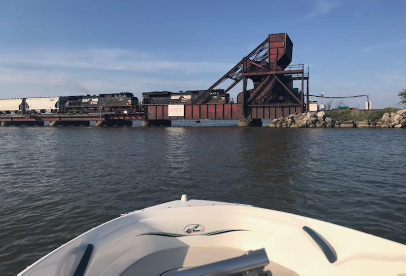 In view from small boat, train crosses bridge