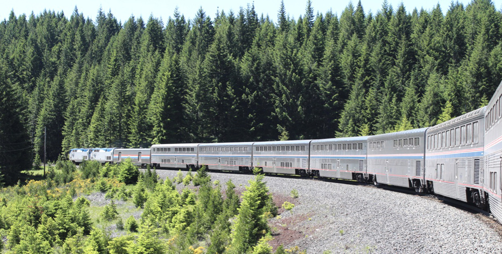 Passenger train rounding sharp curve in mountains