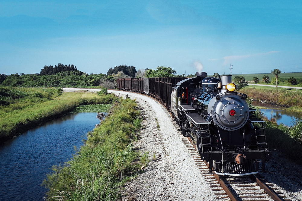 Steam locomotive leads train on curve