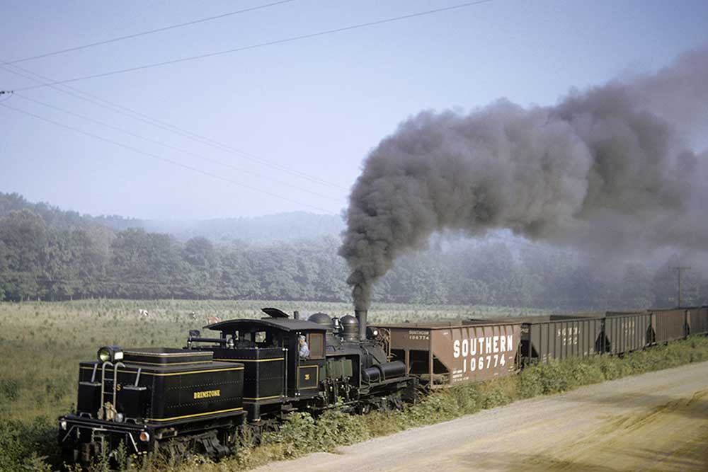 Geared steam locomotive reverses with coal cars