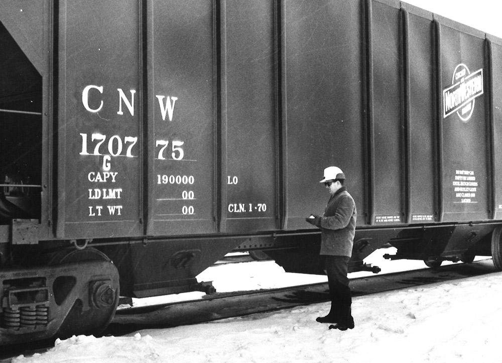Man beside Chicago & North Western covered hopper car