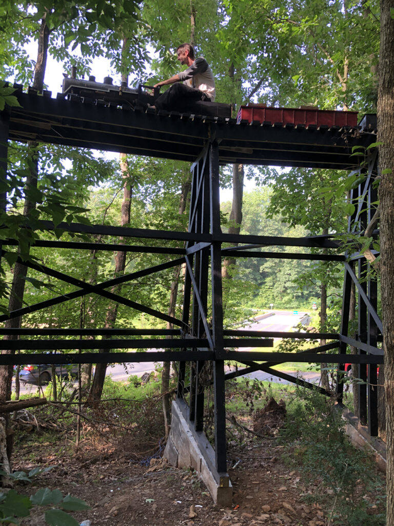 Man on a ride-on train over a trestle