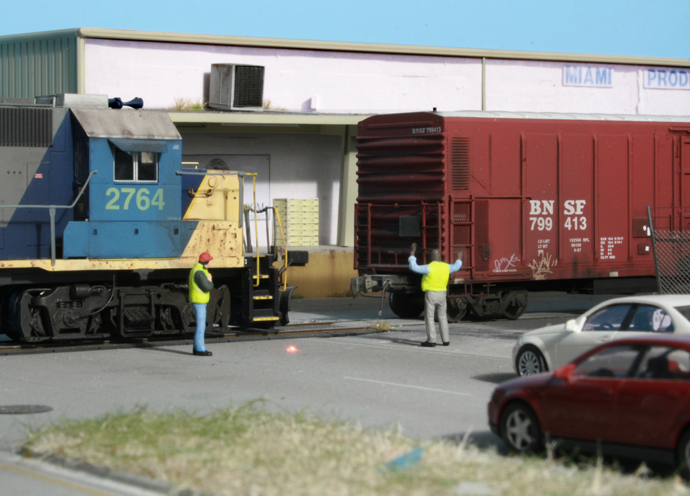 Two model figures next to two model trains