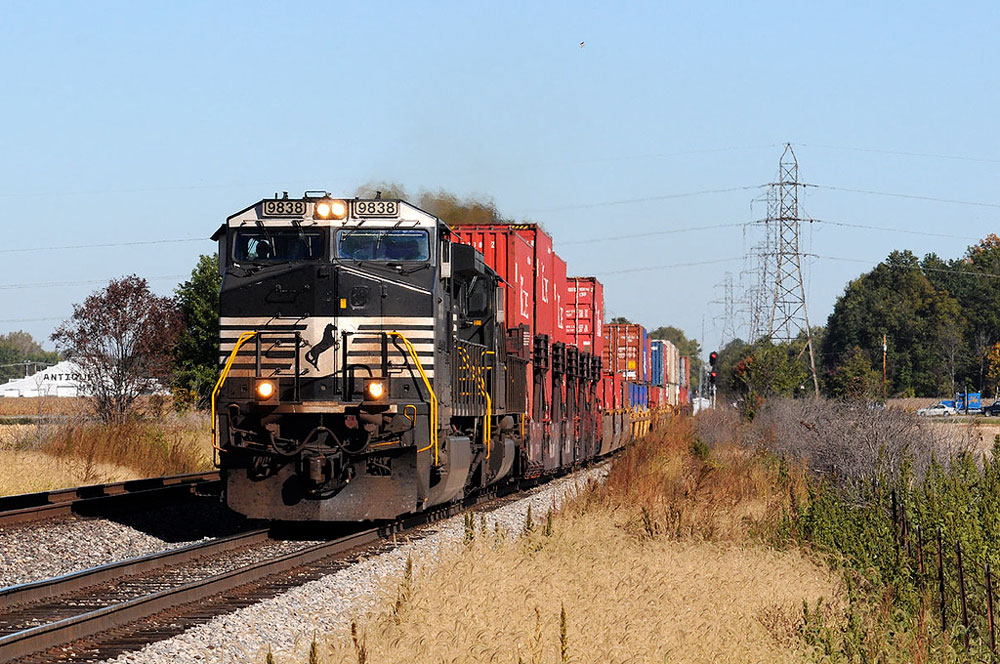 black and white locomotive pulling double stacked containers. Derail the Sale opposed to selling Cincinnati's railroad