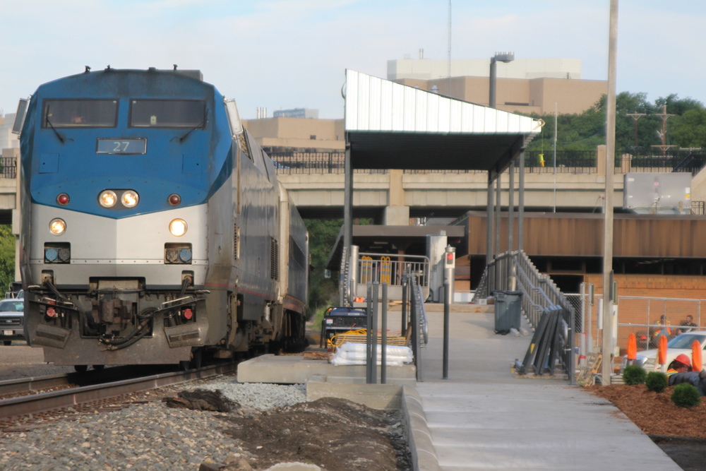 Passenger train passes platform with handicap boarding facilities