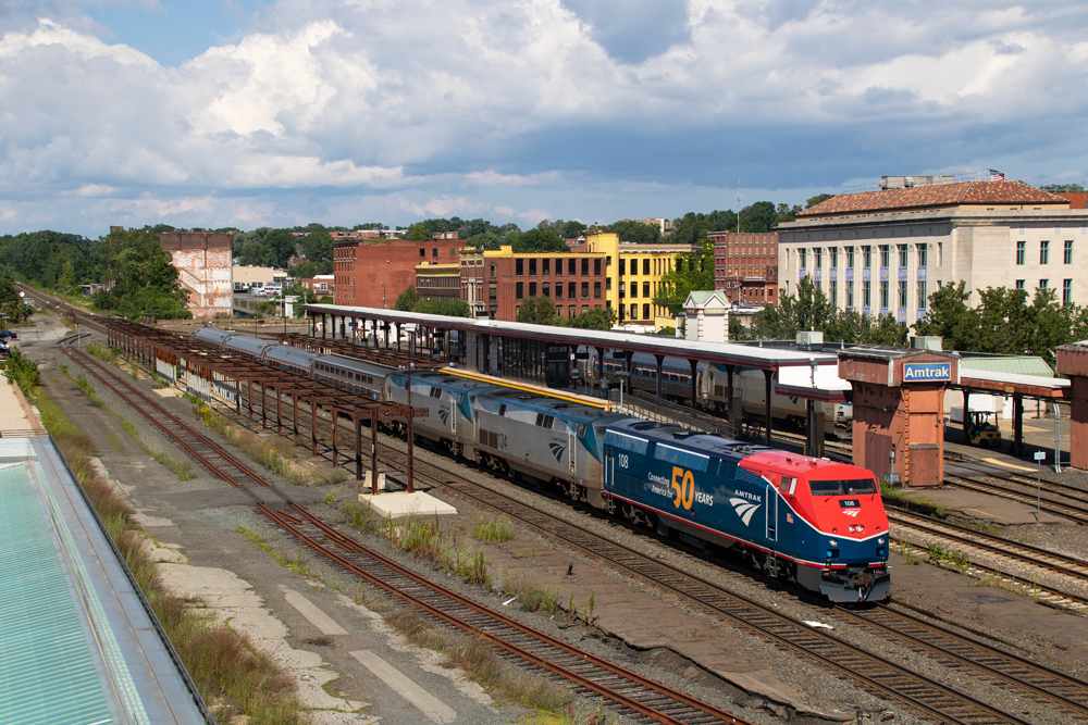 Red and blue locomotive leads passenger train