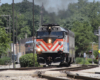 Train arrives at one-story brick station.