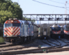 Train on main line passes three parked trains.