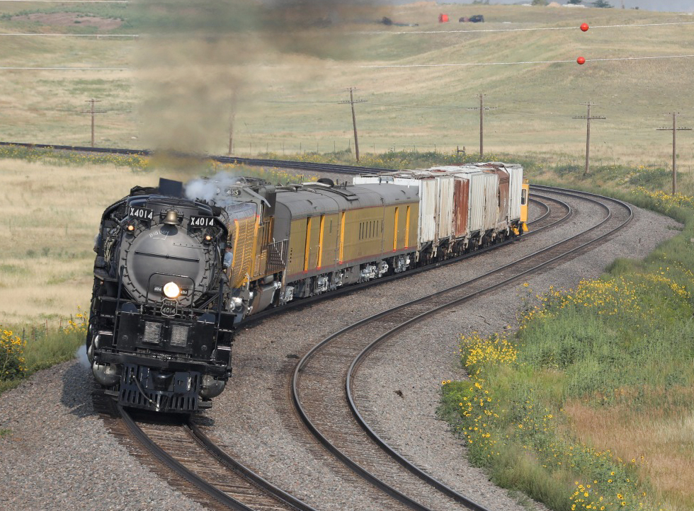 Steam locomotive pulling mix of passenger and frieght cars