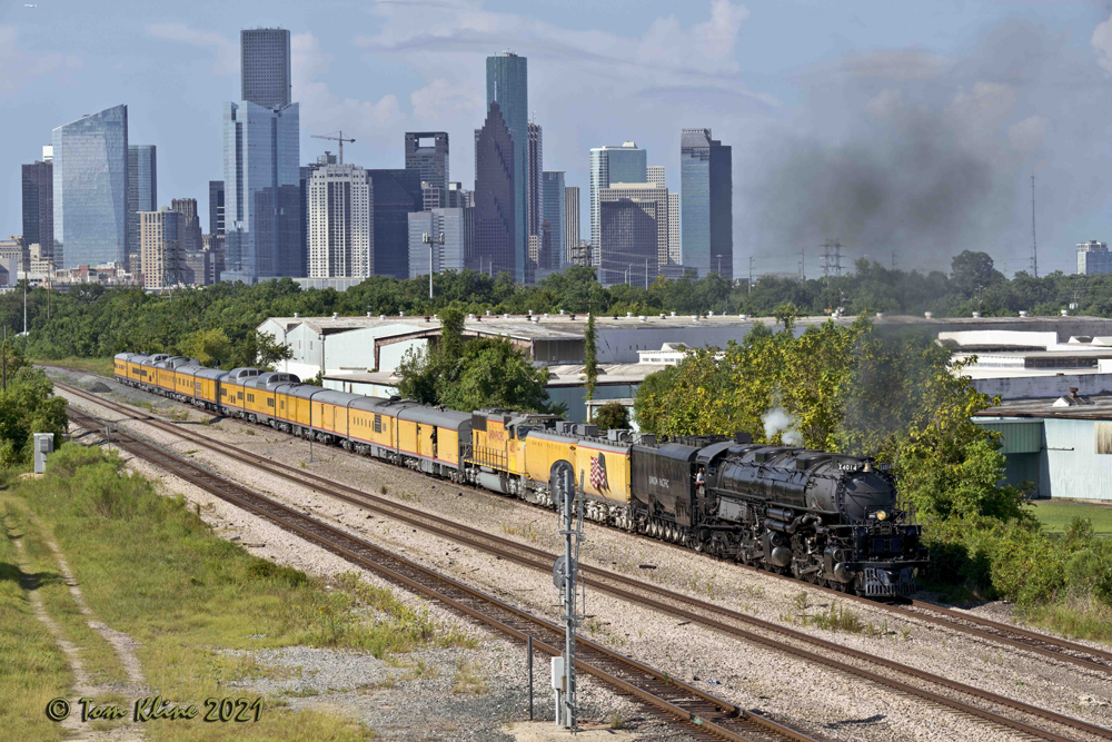 Steam locomotive and diesel pulling yellow passenger train