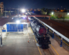 Big Boy steam locomotive rests on track at nighttime surrounded by lights.